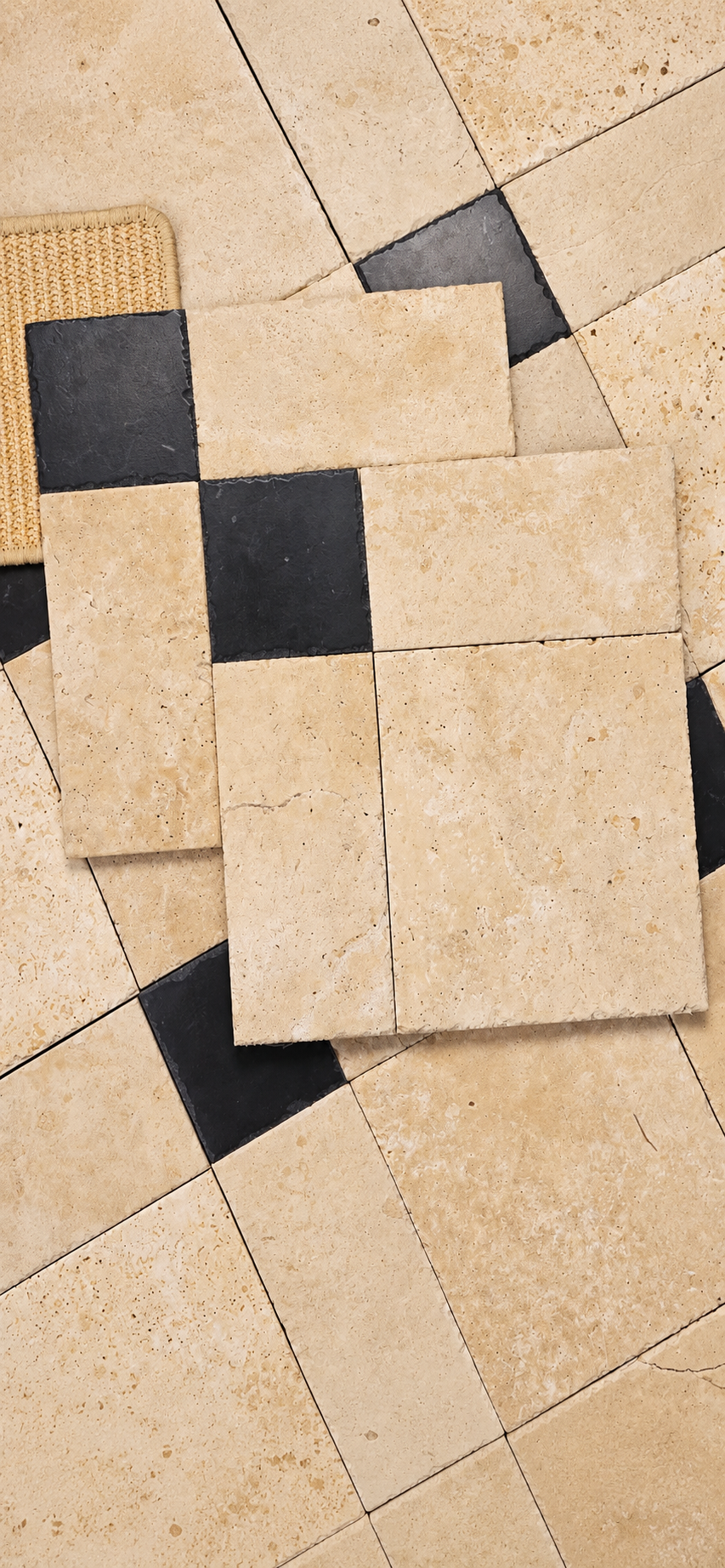 Beige stone-look rectangular floor tiles arranged in a pattern with alternating black square tiles, shown on a matching tiled surface.