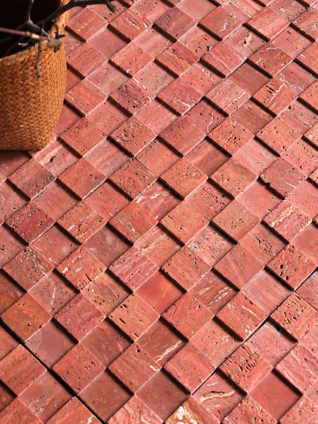Terracotta red mosaic tile backsplash in a diagonal stacked pattern, with a woven basket prop in the top-left corner.