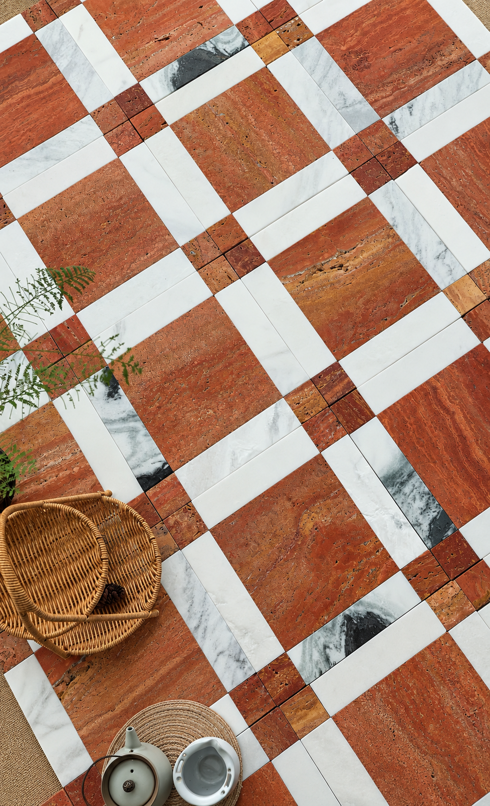 A styled overhead view of a checkered tile floor featuring alternating warm terracotta-brown stone tiles and white marble tiles, with decorative wicker baskets and small metal containers placed on the floor.